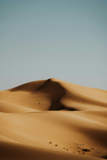 Grande duna de areia em meio a um deserto, estética que remete ao planeta Arrakis